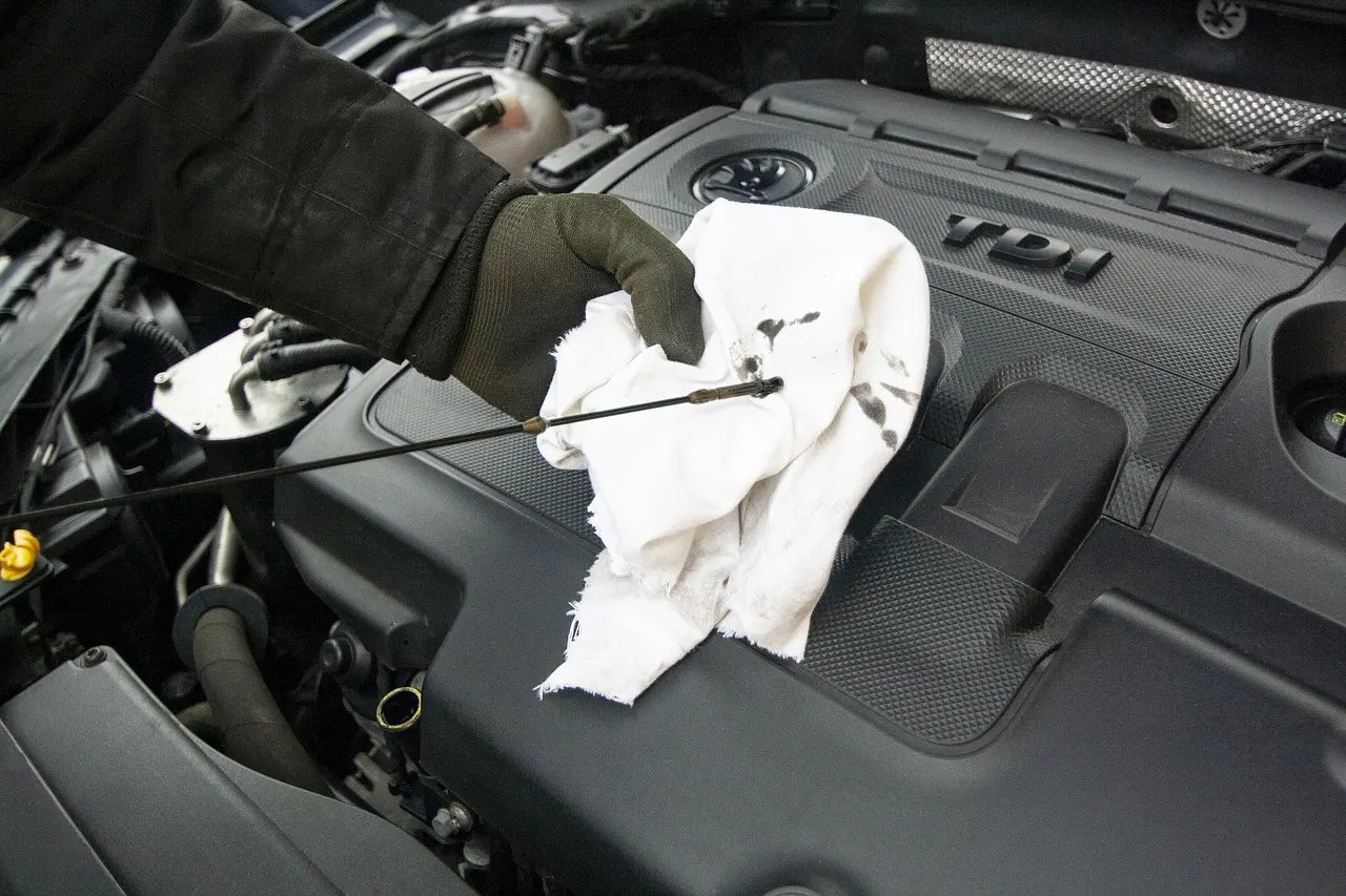 Image shows man holding oil dip stick.