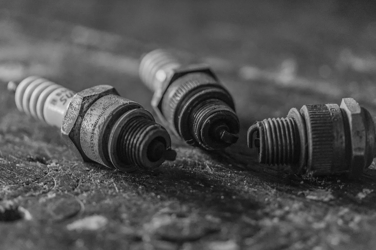 Shows worn-out spark plugs on ground.